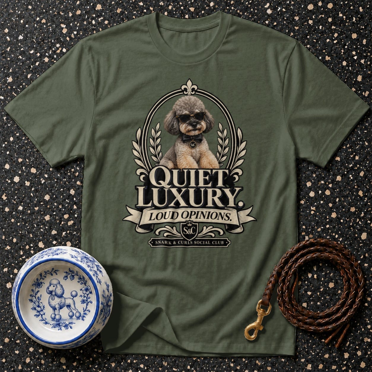 Olive green t-shirt with a poodle wearing sunglasses and text "QUIET LUXURY, LOUD OPINIONS".