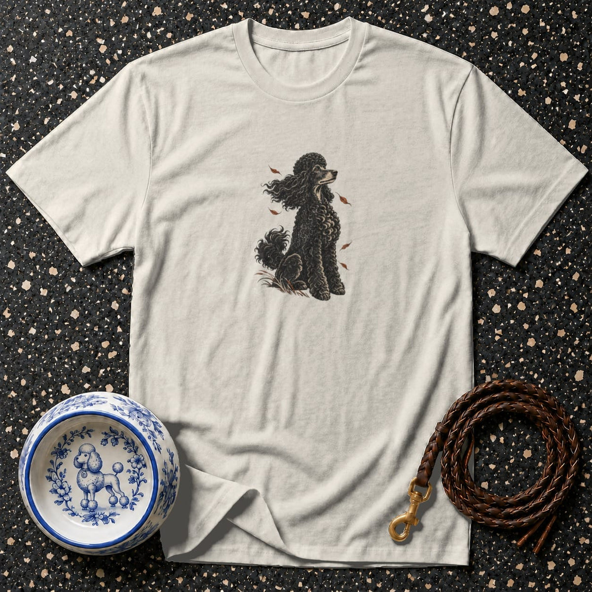 Cream t-shirt with black poodle illustration, dog bowl, and braided leather leash.