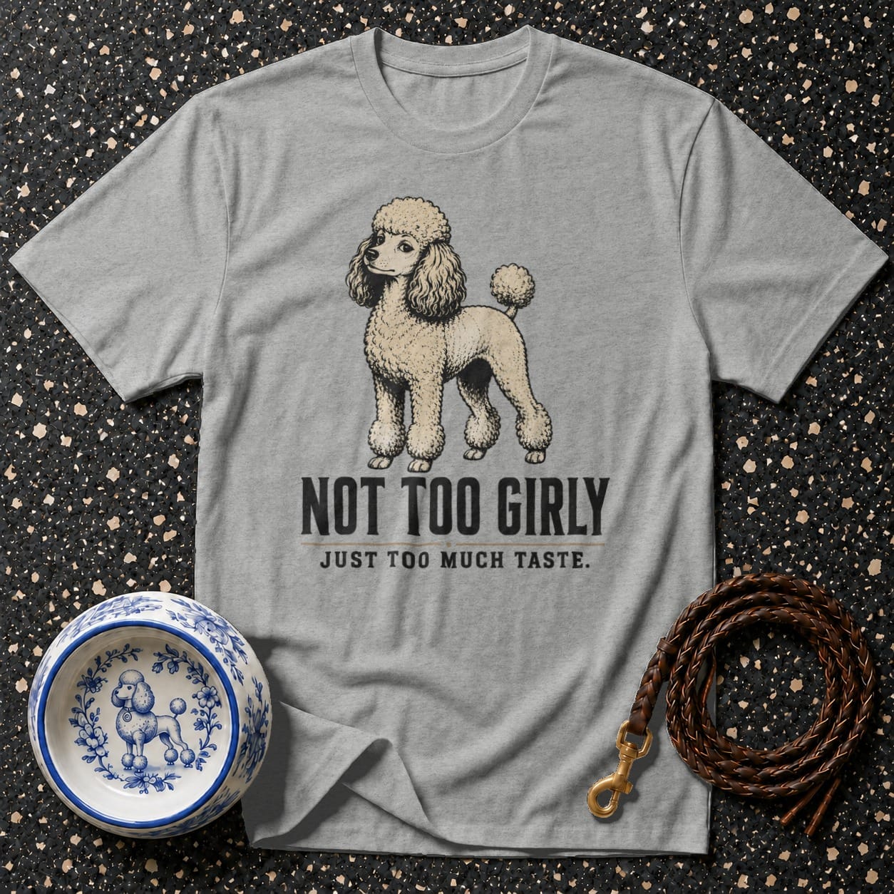 Grey t-shirt with a poodle illustration that reads "NOT TOO GIRLY JUST TOO MUCH TASTE."