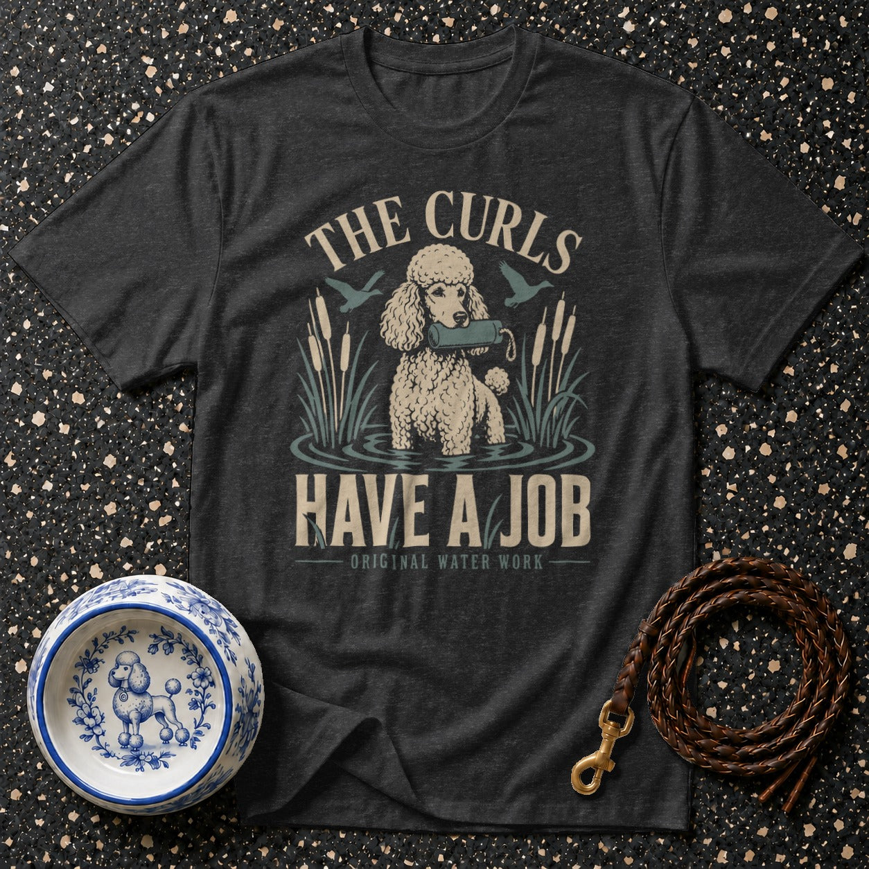 T-shirt graphic: poodle in water with retrieve dummy, text "The Curls Have A Job".