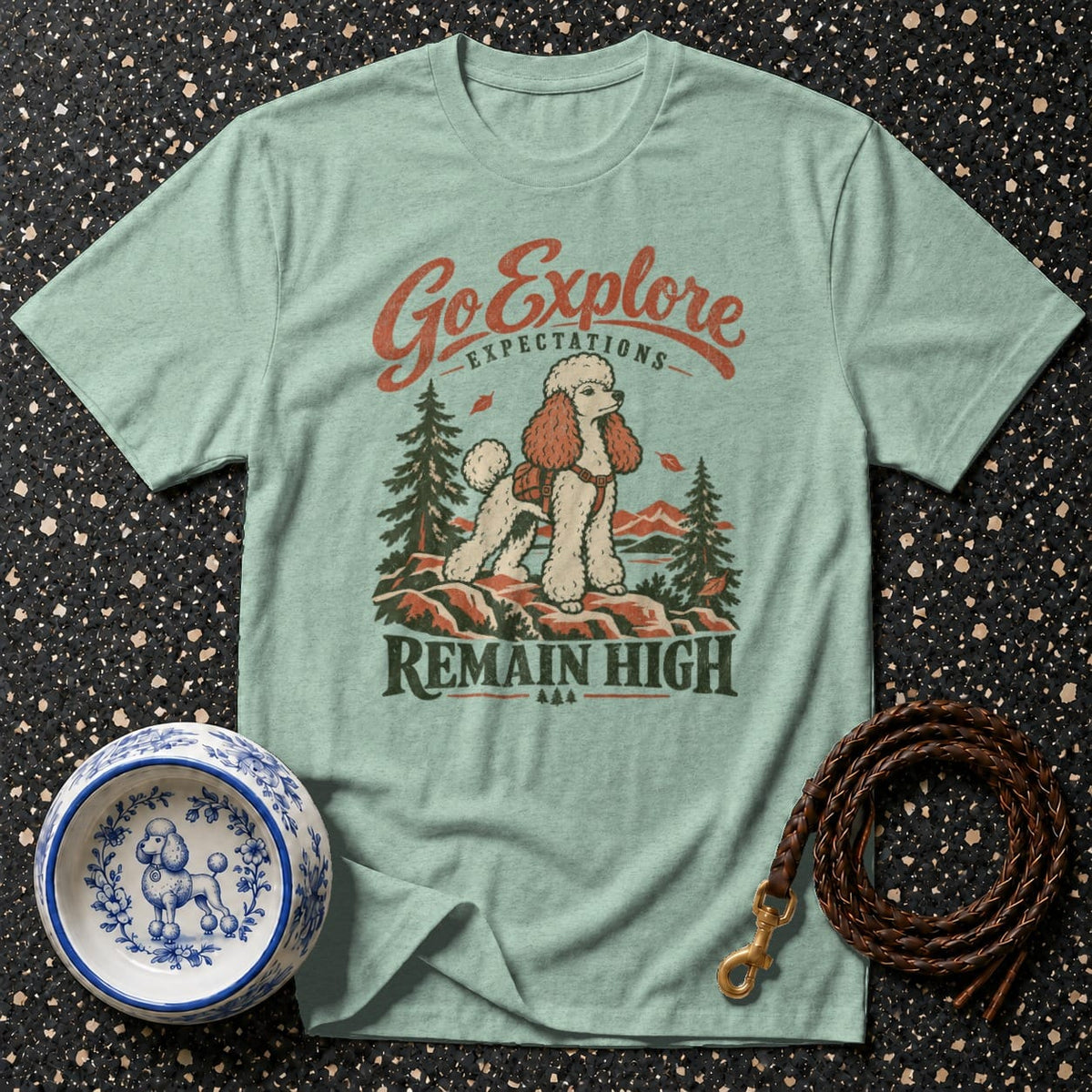 Light green t-shirt with a poodle wearing a backpack on a mountain, "Go Explore" and "Remain High" text.