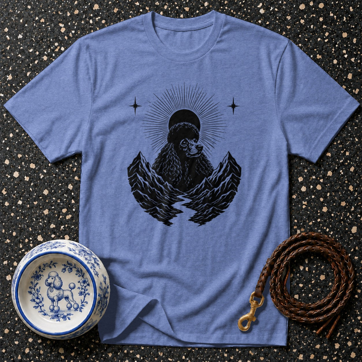 Blue t-shirt with black poodle and mountain graphic, dog bowl, and leather leash.