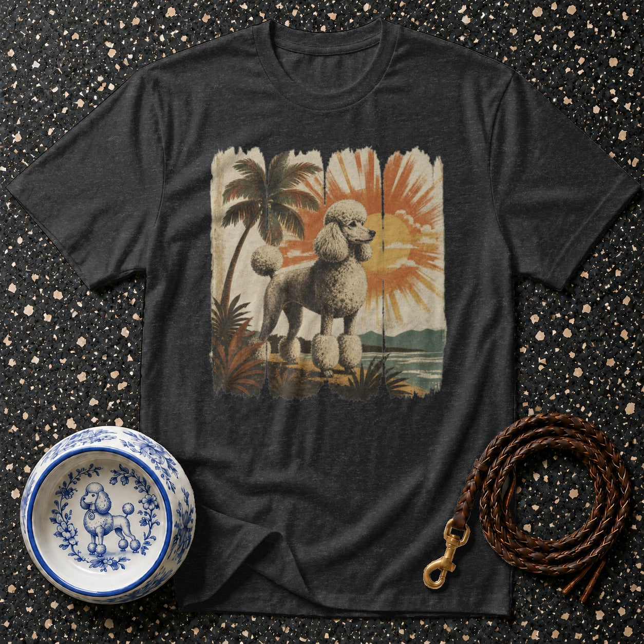 Dark gray t-shirt with a retro tropical poodle graphic and surrounding pet accessories.