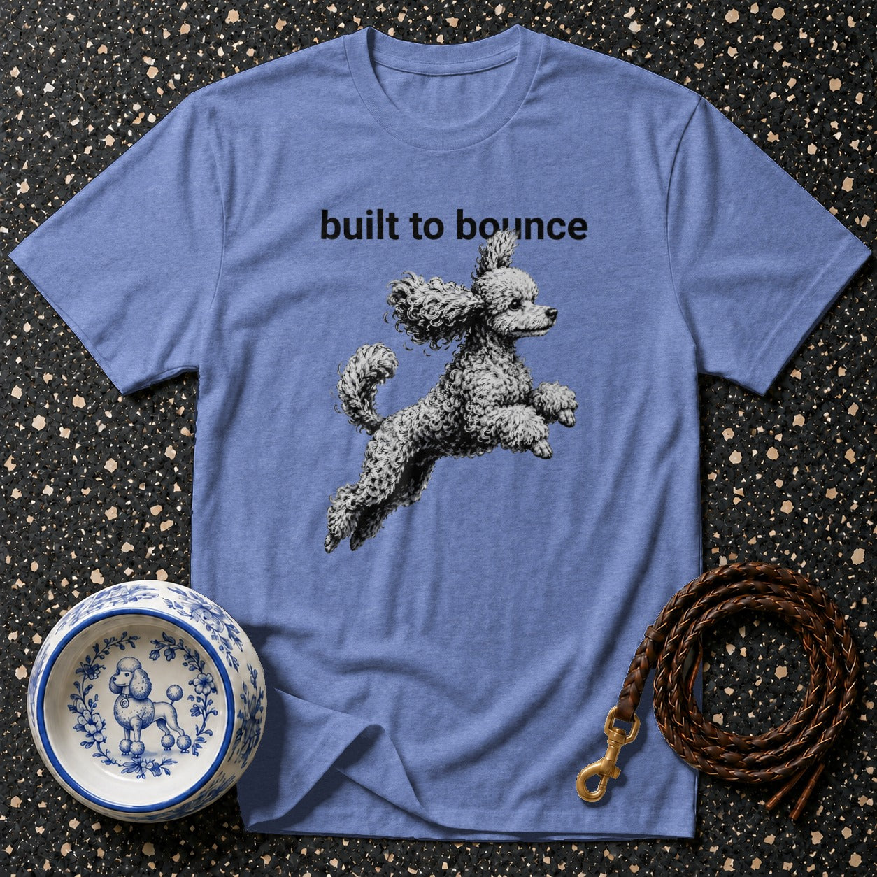 Light blue t-shirt with "built to bounce" and a poodle graphic.