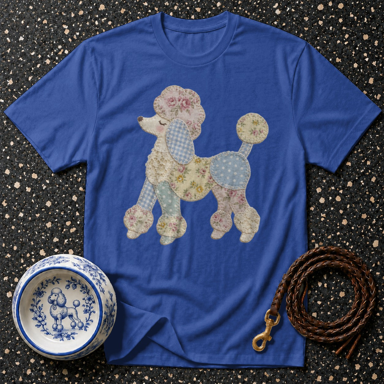 Blue t-shirt with a patchwork poodle graphic, pet bowl, and leather leash.