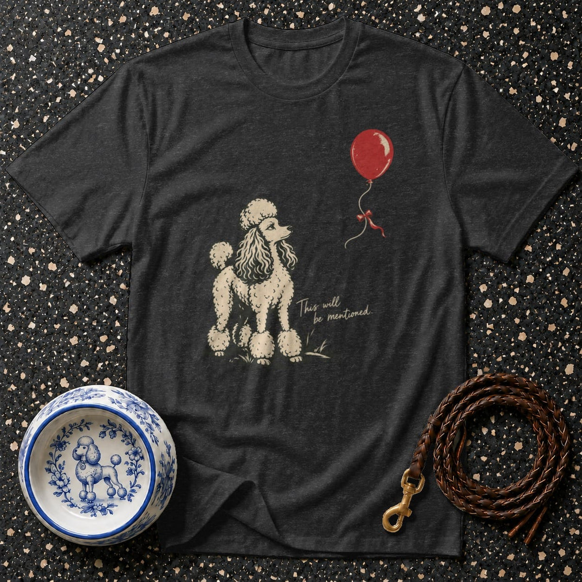 Dark t-shirt with a vintage poodle illustration and red balloon graphic with text.