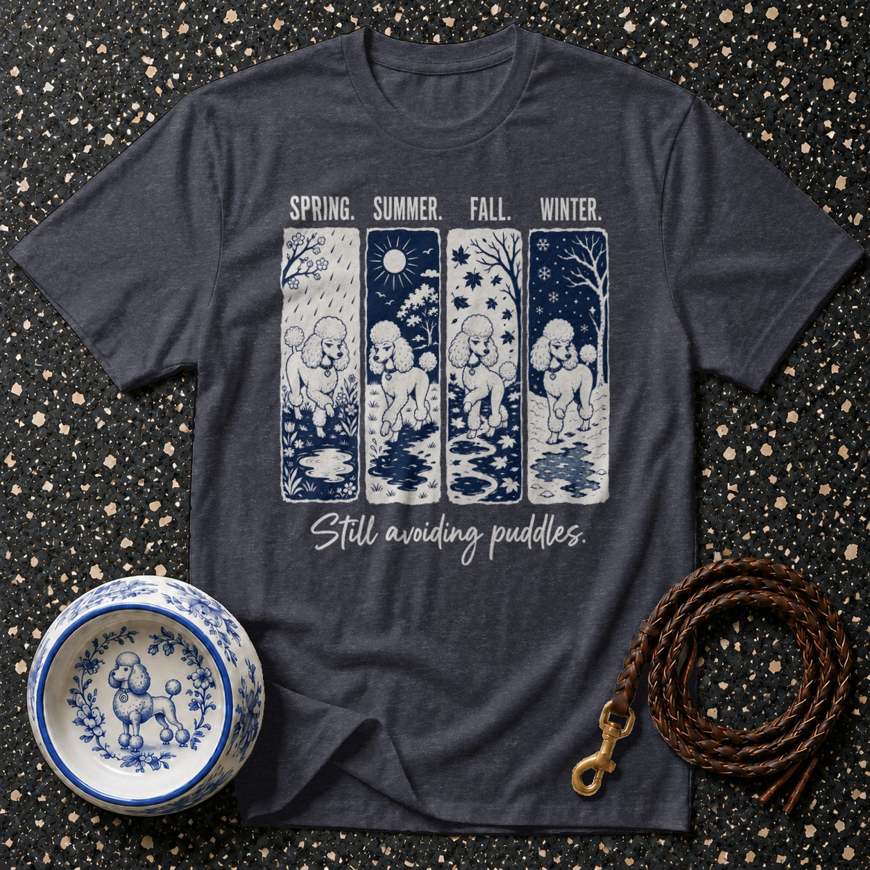 Dark t-shirt with a graphic of four poodles in spring, summer, fall, and winter scenes.