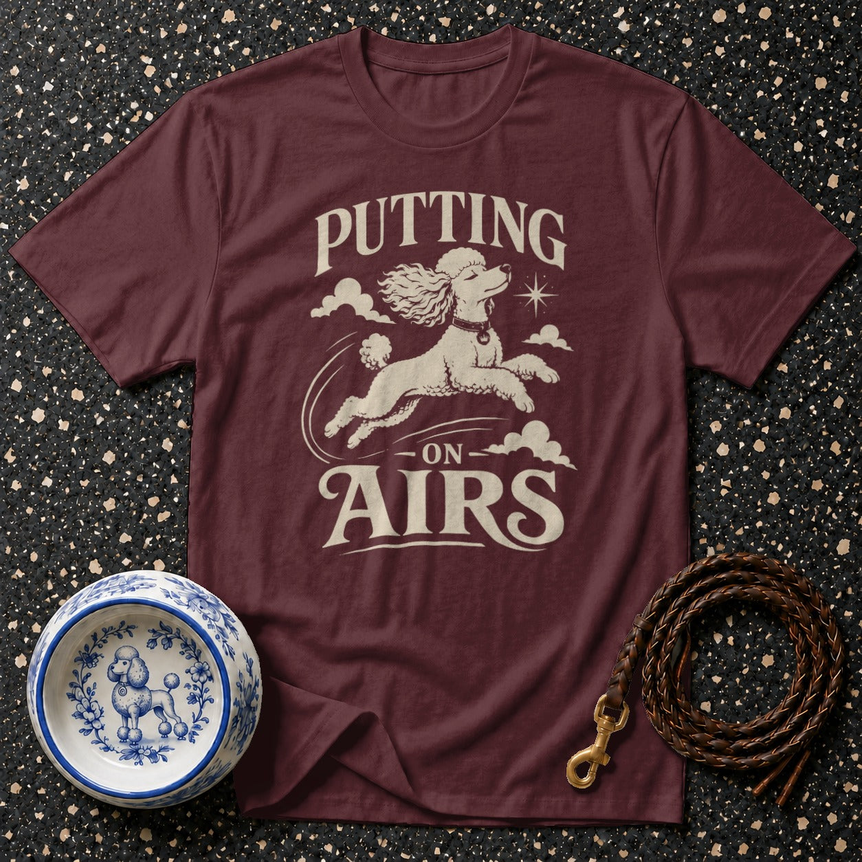 Maroon t-shirt with "Putting On Airs" text and leaping poodle graphic.