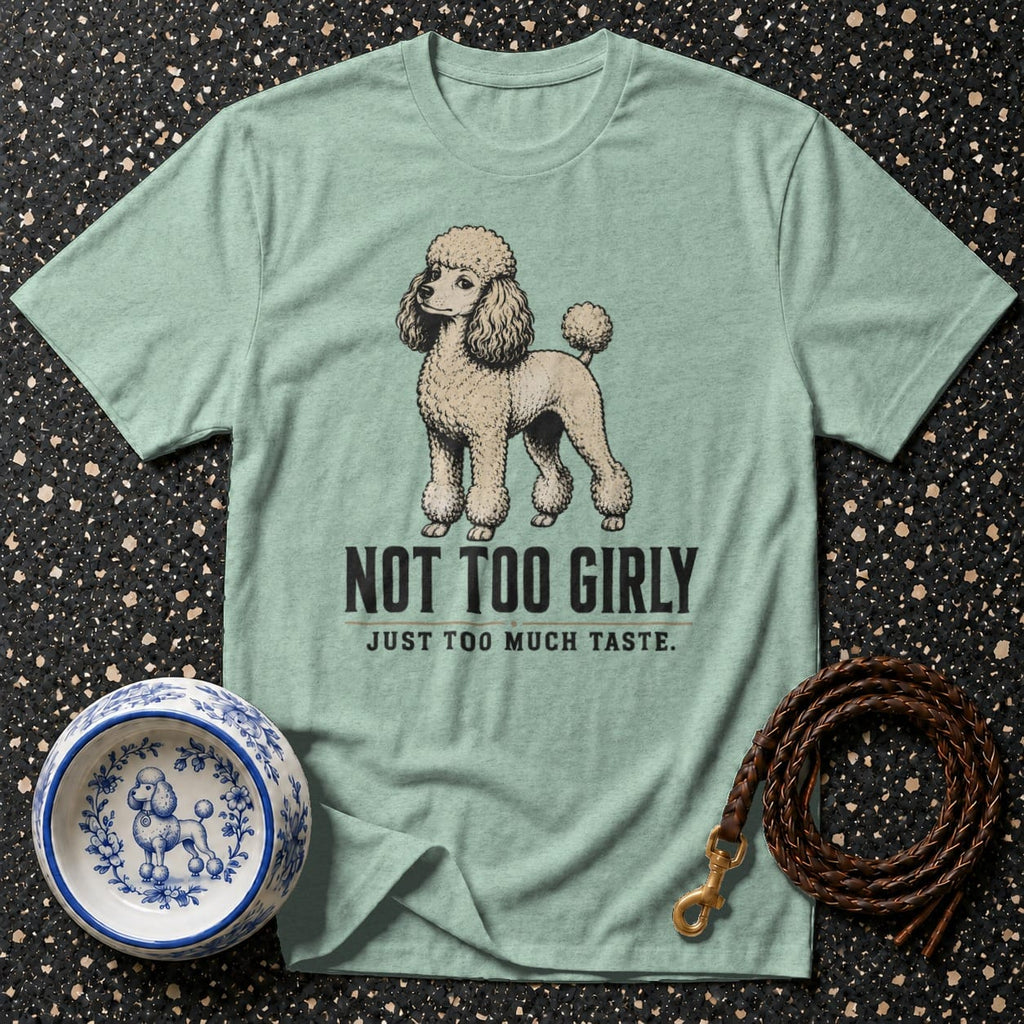 Light blue t-shirt with a poodle illustration and text "NOT TOO GIRLY JUST TOO MUCH TASTE."
