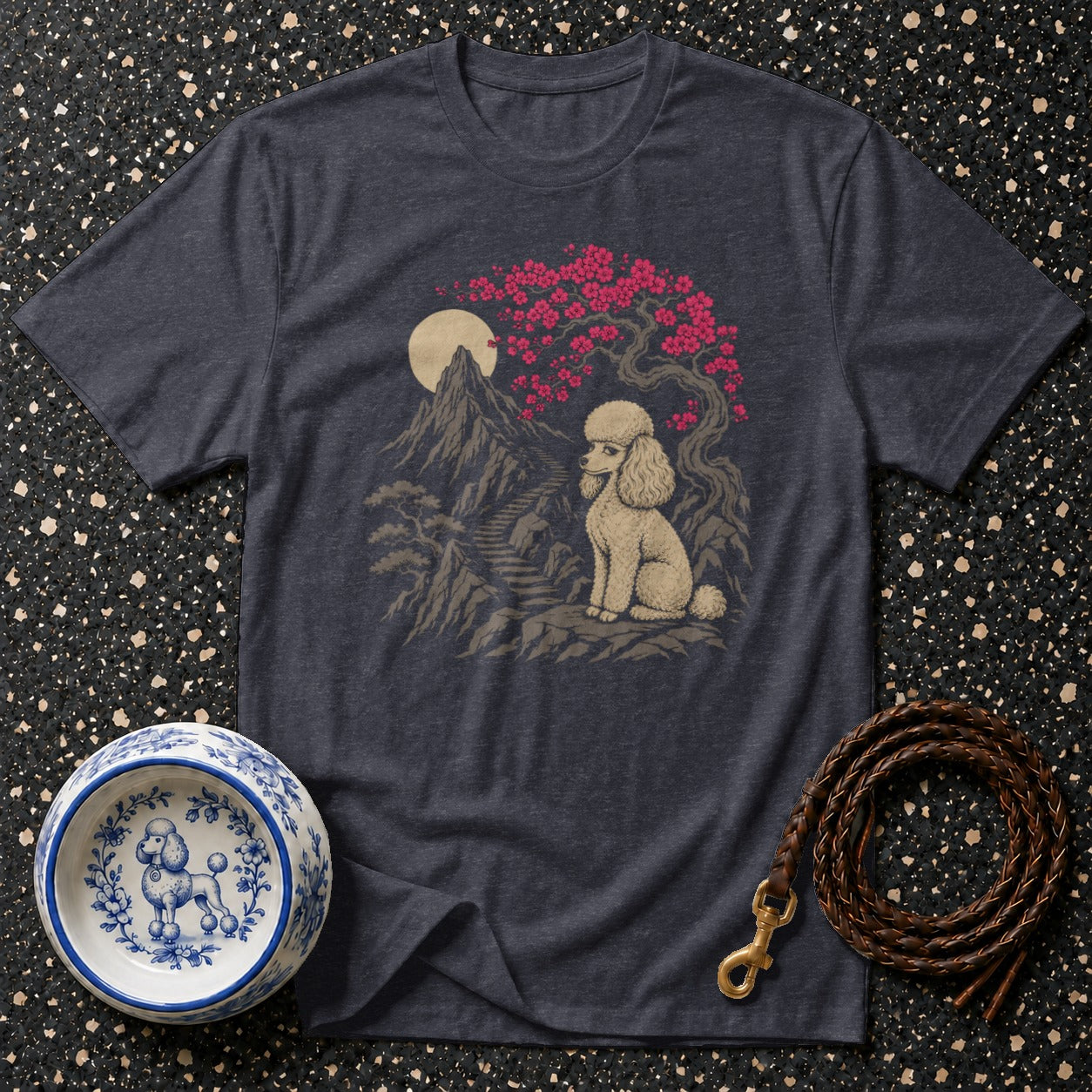 Dark t-shirt with a graphic of a poodle under a blooming cherry tree and mountains.