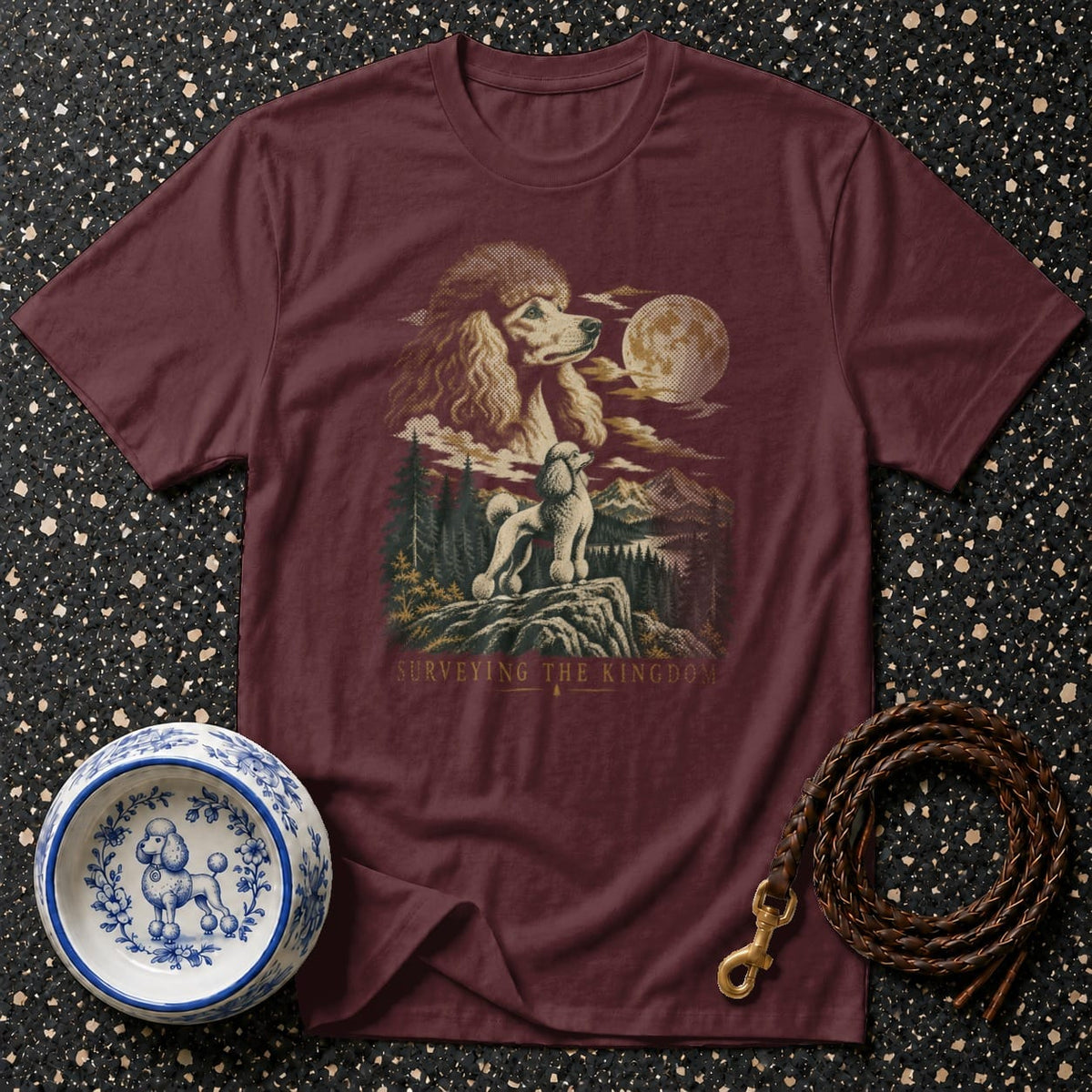 Maroon t-shirt with a vintage art print of two poodles overlooking a mountain landscape under a full moon, with gold text.