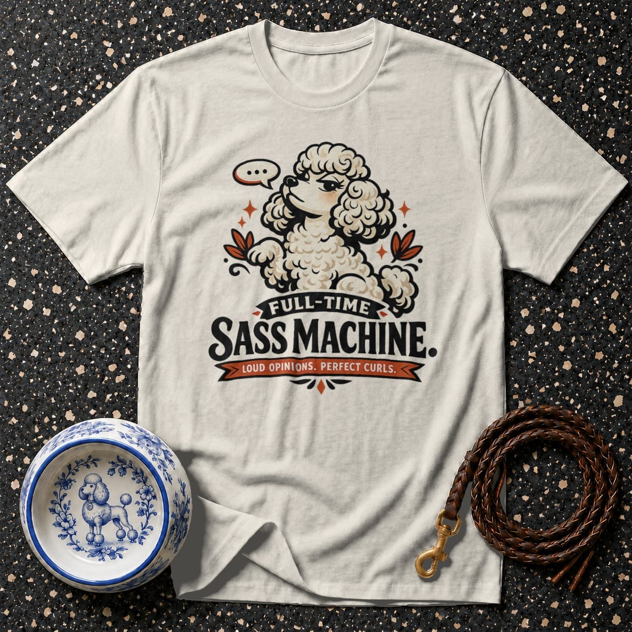 Cream t-shirt with a cartoon poodle graphic and text that reads "FULL-TIME SASS MACHINE. LOUD OPINIONS. PERFECT CURLS."