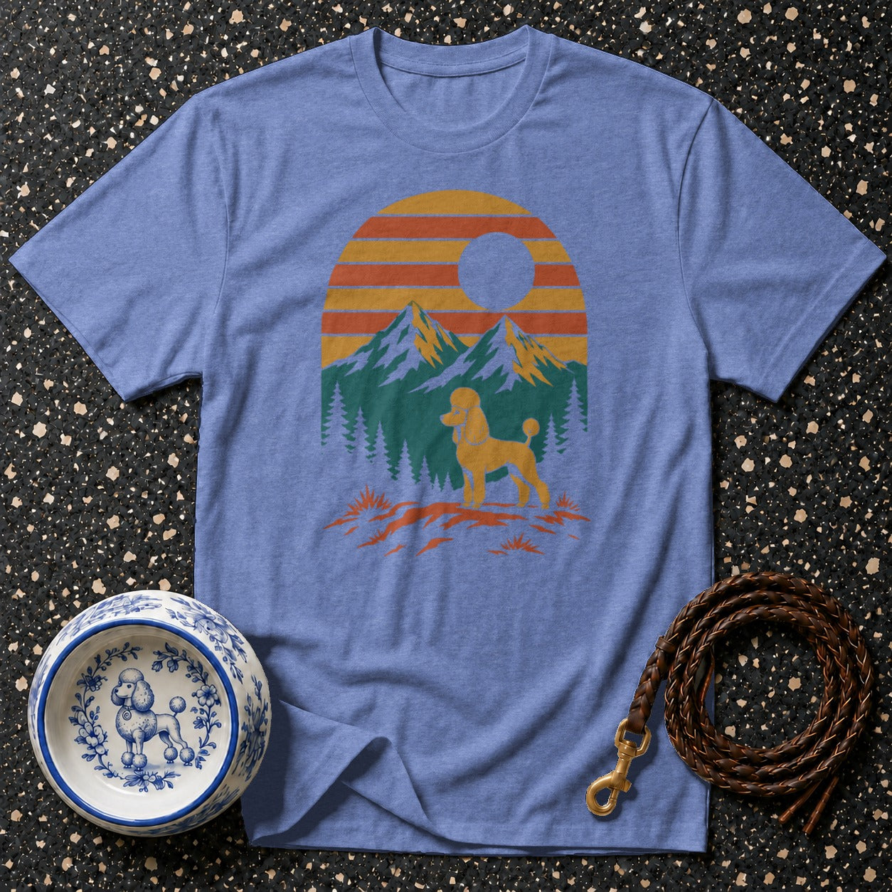 Blue t-shirt with a poodle silhouette against a sunset mountain landscape.