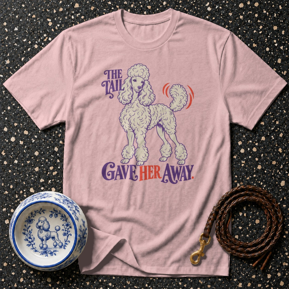 Pink t-shirt with poodle graphic and text "The Tail Gave Her Away."