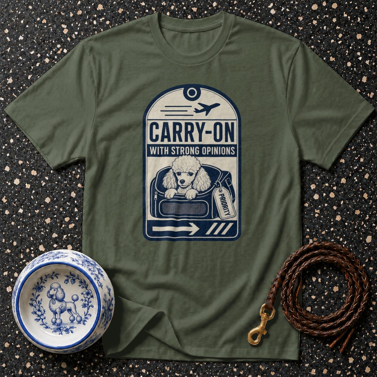 T-shirt with a poodle in a carrier labeled "CARRY-ON WITH STRONG OPINIONS".