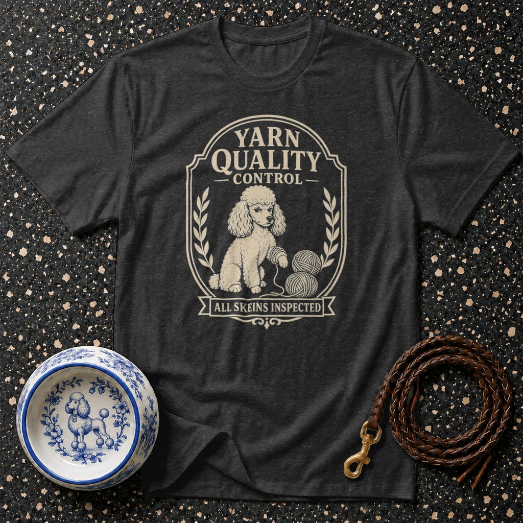 A poodle sits with yarn skeins on a dark t-shirt with "Yarn Quality Control" text.
