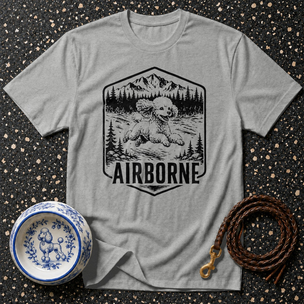 Grey t-shirt with a graphic of a poodle running in a forest, mountains, and the word AIRBORNE.