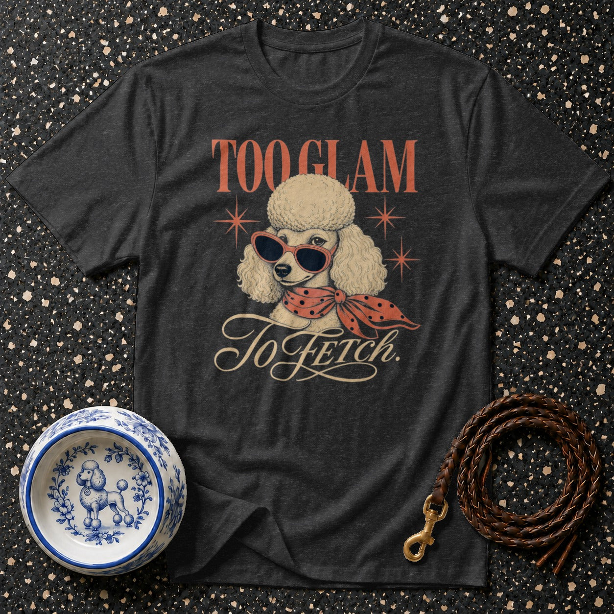 Dark t-shirt with graphic of a poodle wearing sunglasses and a scarf, text "TOO GLAM To Fetch."