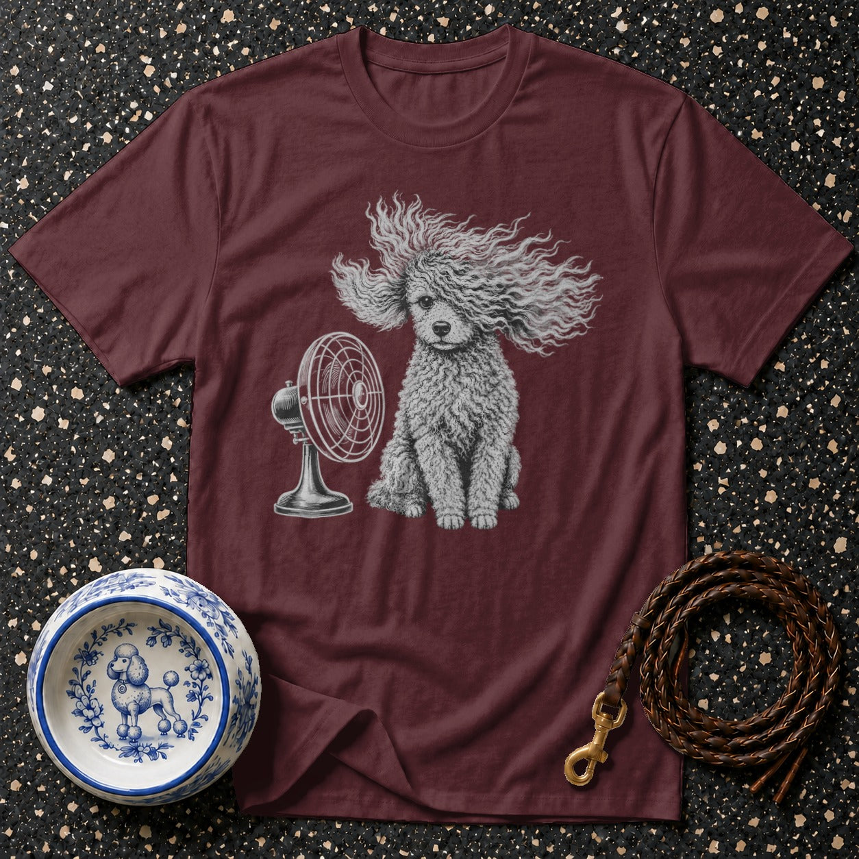 Maroon t-shirt with illustration of a poodle sitting in front of a fan.
