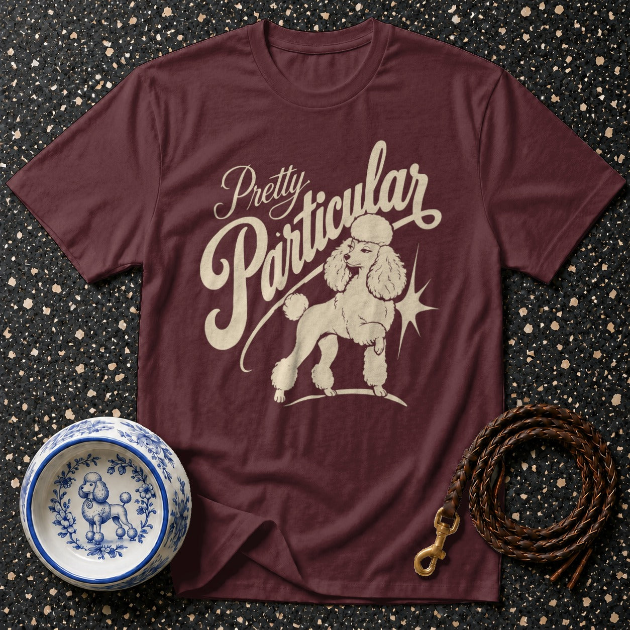 Maroon t-shirt with "Pretty Particular" text and poodle graphic.