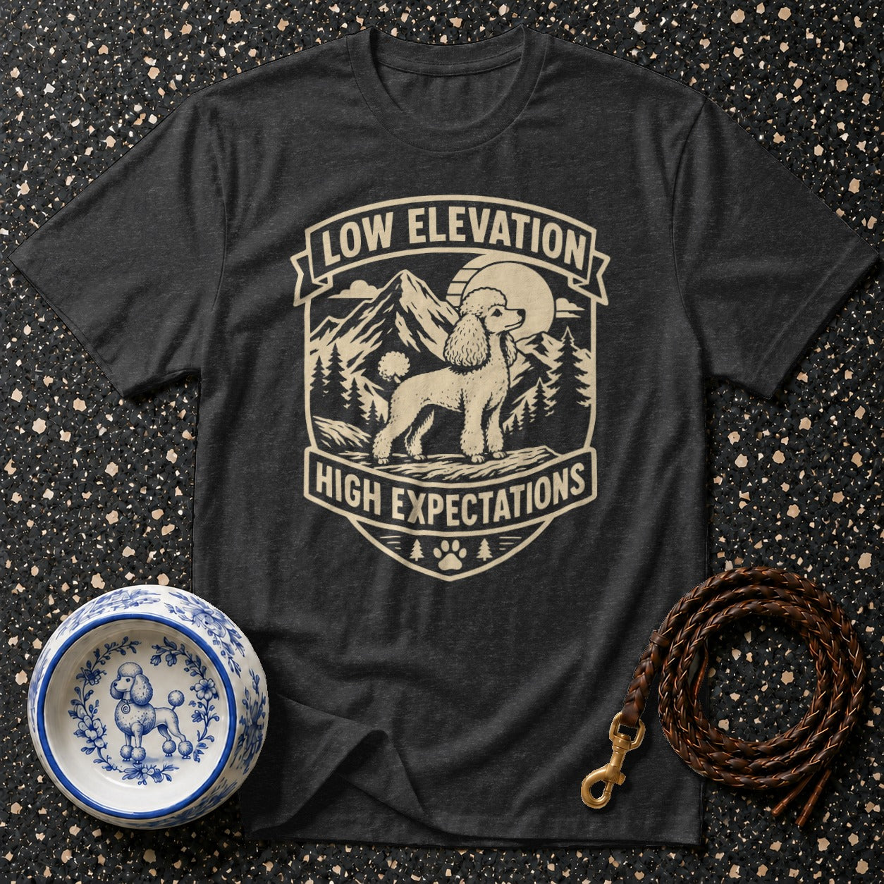 Dark grey t-shirt with a poodle and mountain graphic that says "Low Elevation High Expectations".