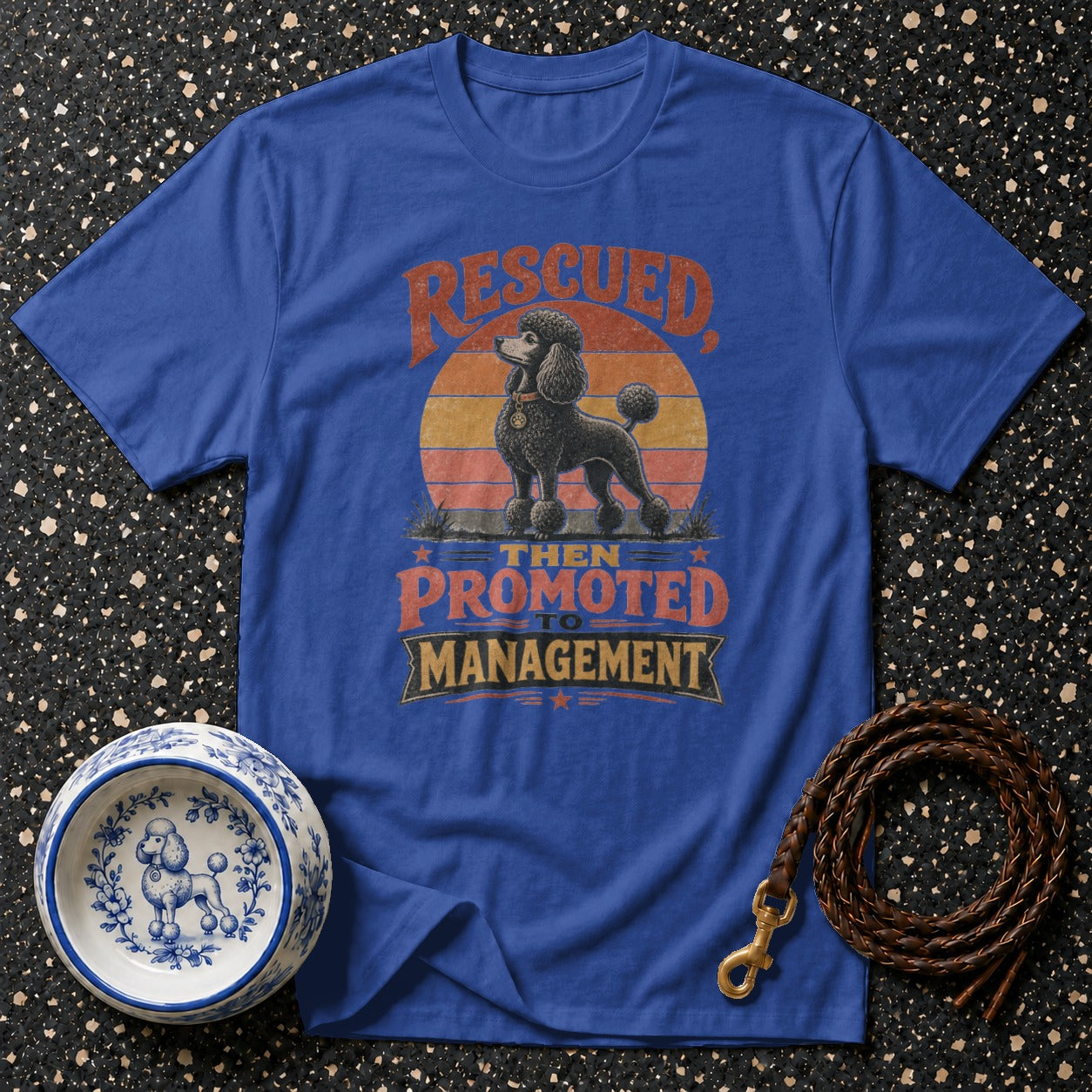 Blue t-shirt with vintage distressed graphic of a poodle and text "Rescued Then Promoted To Management".