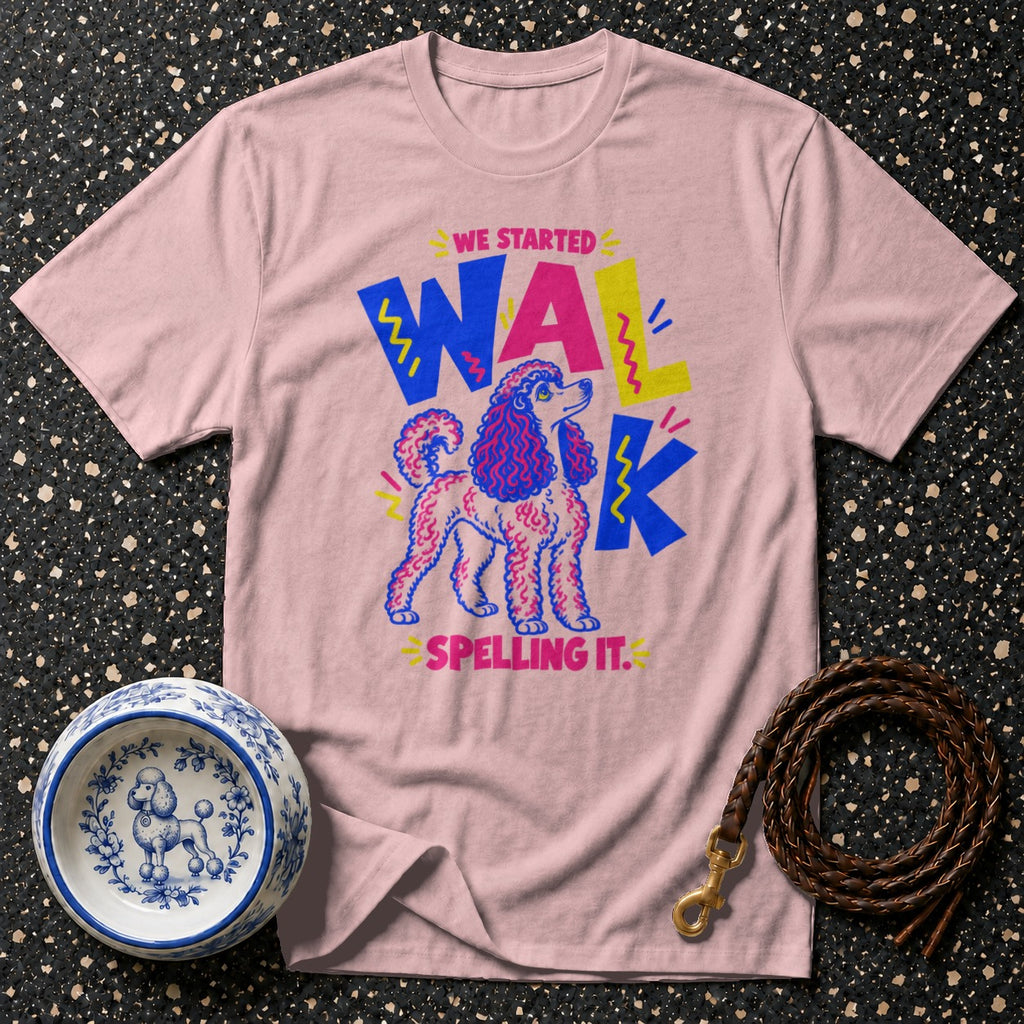 Pink t-shirt with a poodle graphic and "WE STARTED WALK SPELLING IT." text.