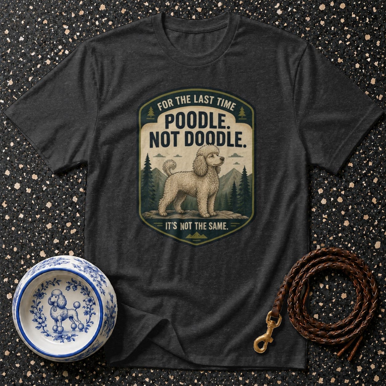 Dark grey t-shirt with a graphic of a poodle and text "POODLE. NOT DOODLE."