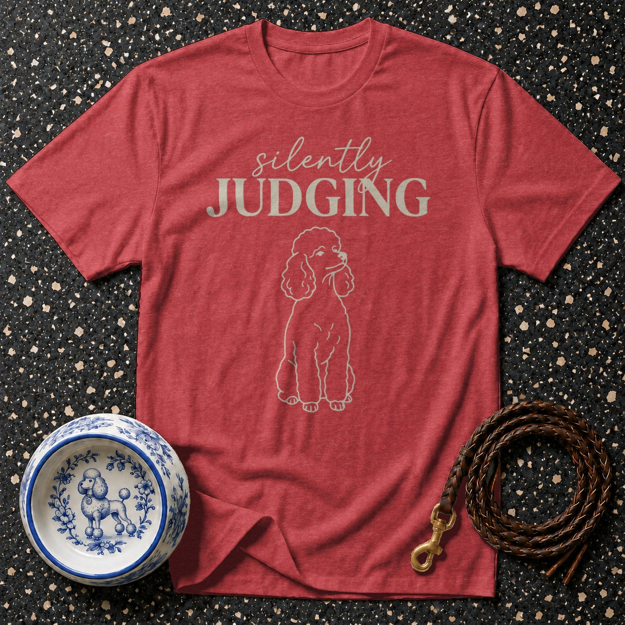 Red t-shirt with "silently JUDGING" text and poodle graphic, with dog bowl and leash.