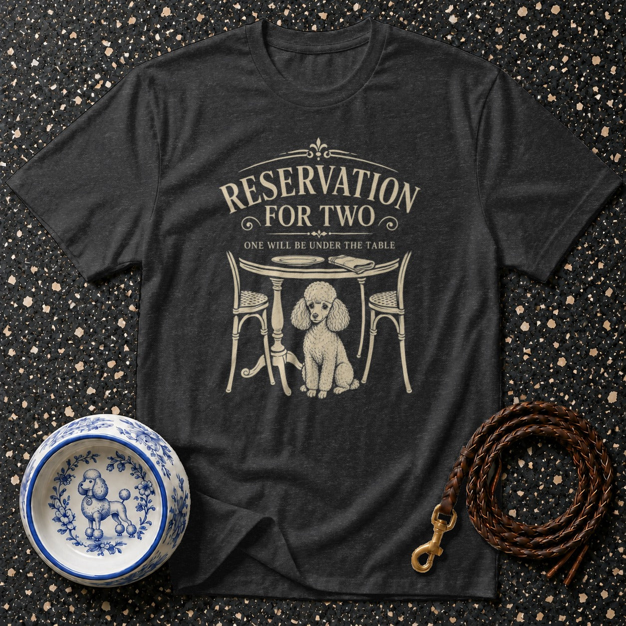 Dark grey t-shirt with poodle under a table and text "RESERVATION FOR TWO, ONE WILL BE UNDER THE TABLE".