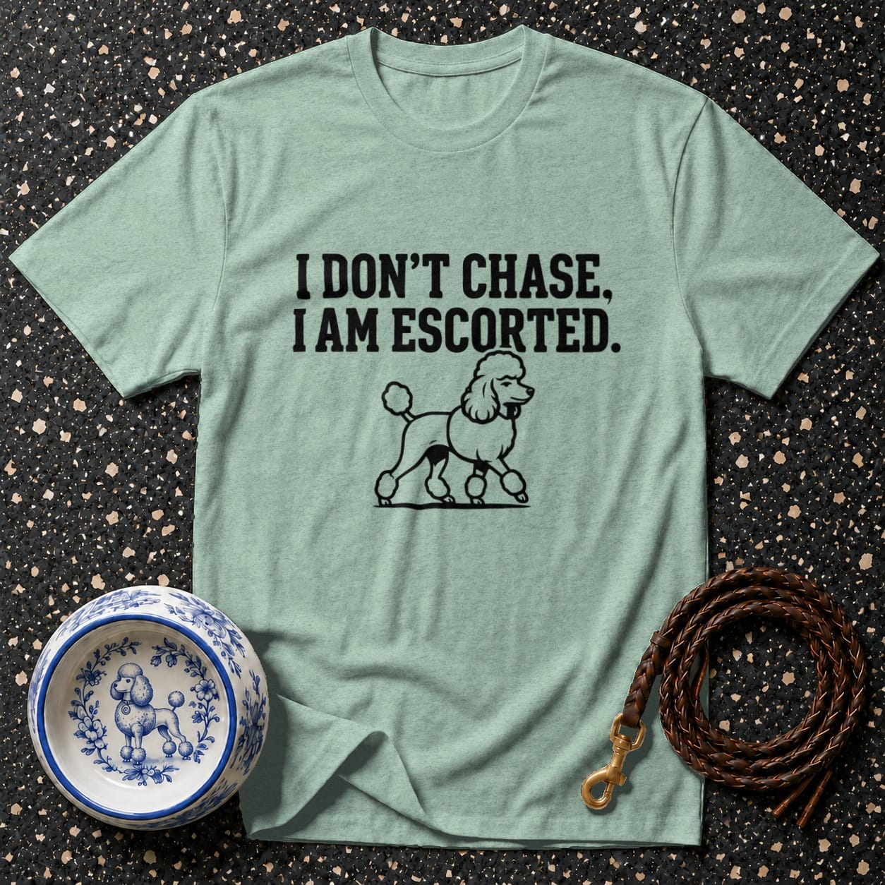 Mint t-shirt with text "I DON'T CHASE, I AM ESCORTED." and a poodle graphic.