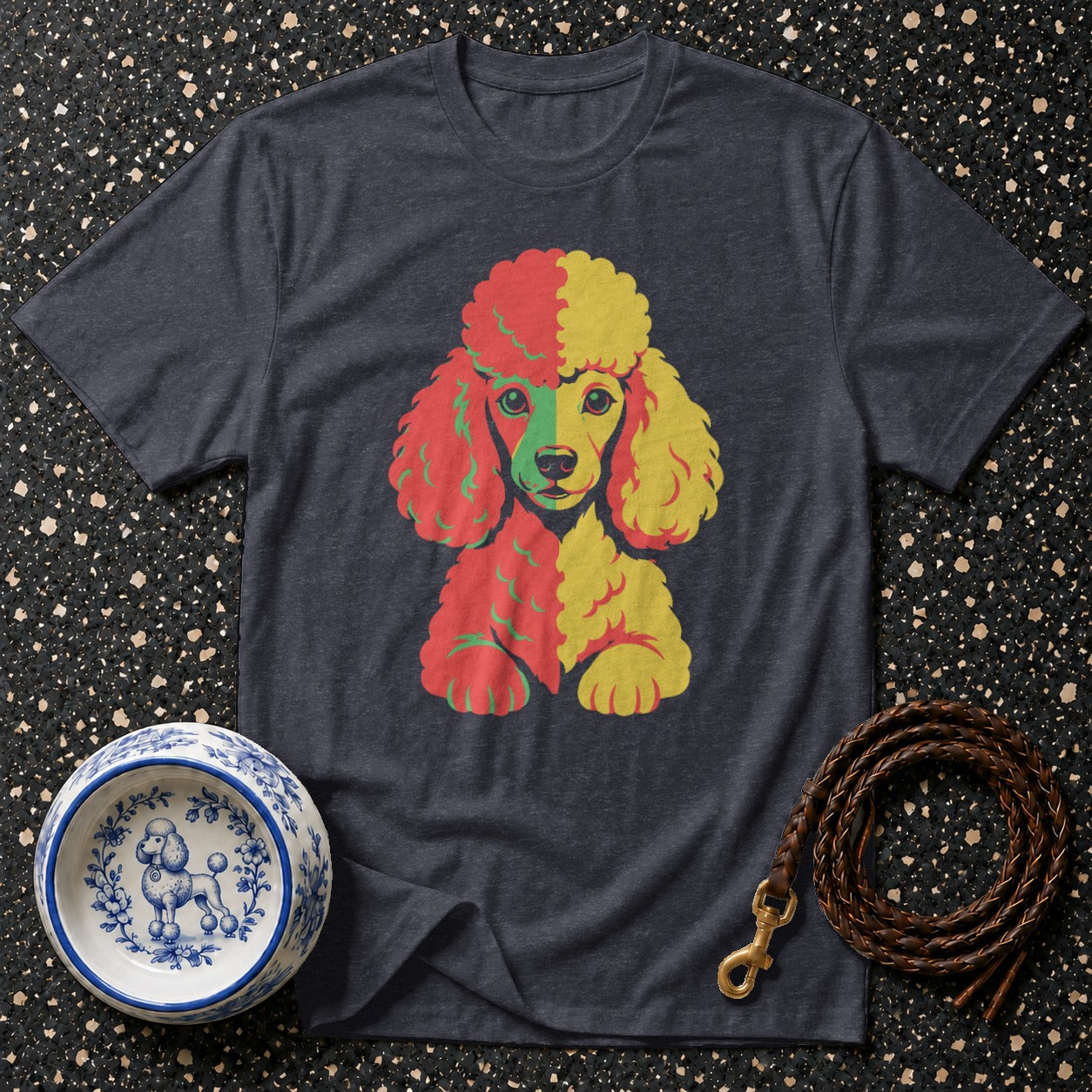 T-shirt with abstract colorful poodle graphic next to a dog bowl and leash.