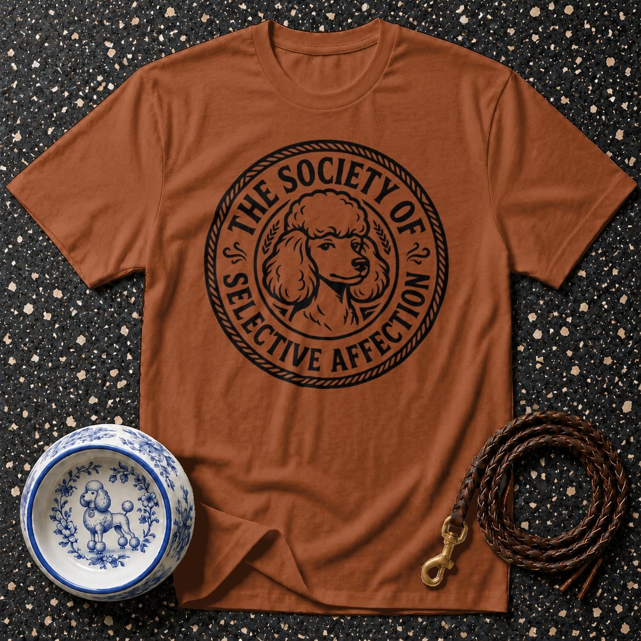 Brown t-shirt with a round black graphic featuring a poodle and text "The Society of Selective Affection."