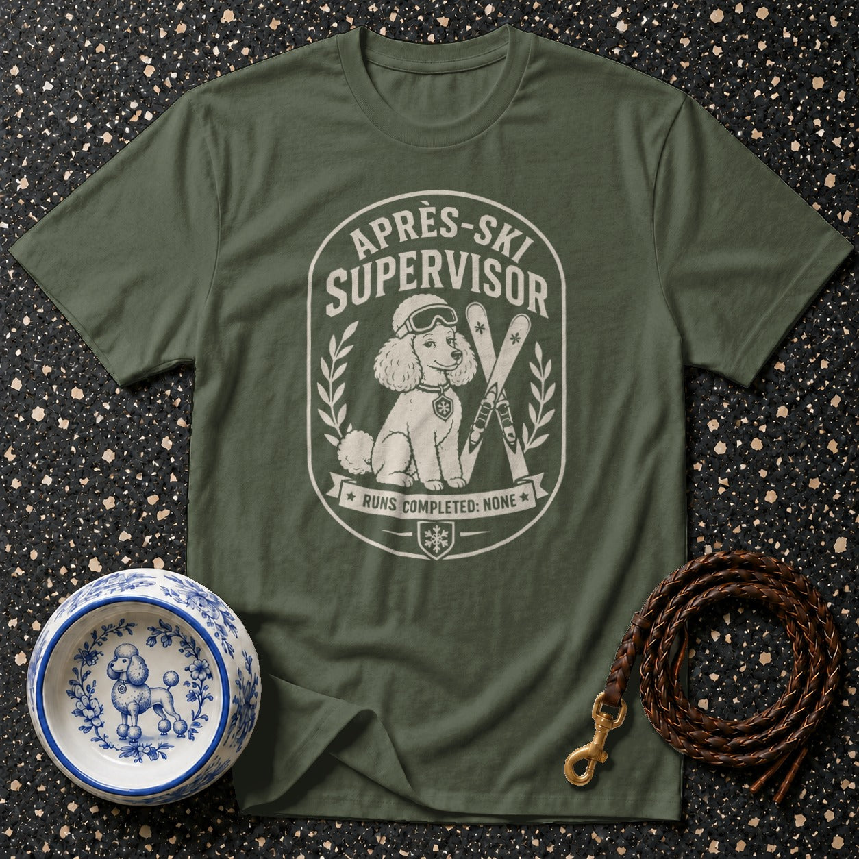 Green t-shirt with "Après-Ski Supervisor" graphic of a poodle and skis.