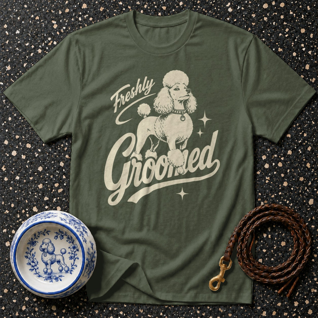 Green t-shirt with a cream poodle graphic and text "Freshly Groomed."