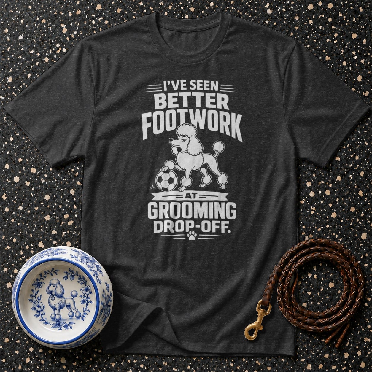 Dark gray t-shirt with white text: "I'VE SEEN BETTER FOOTWORK AT GROOMING DROP-OFF."