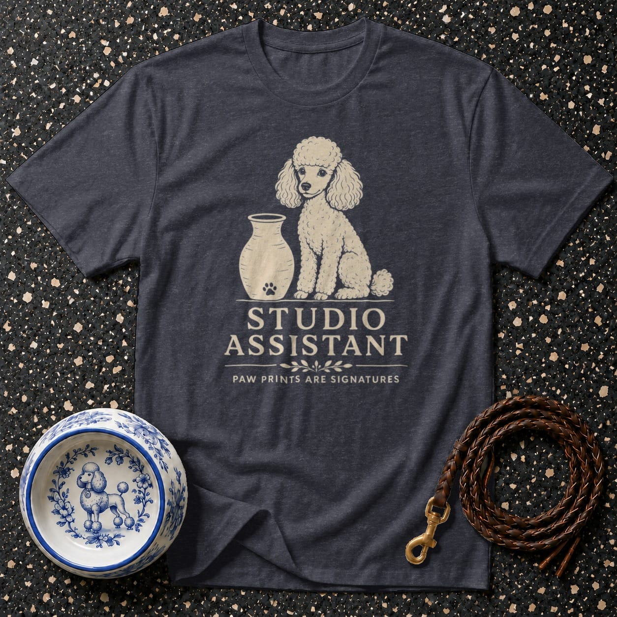 Dark t-shirt with a poodle graphic and "Studio Assistant" text.