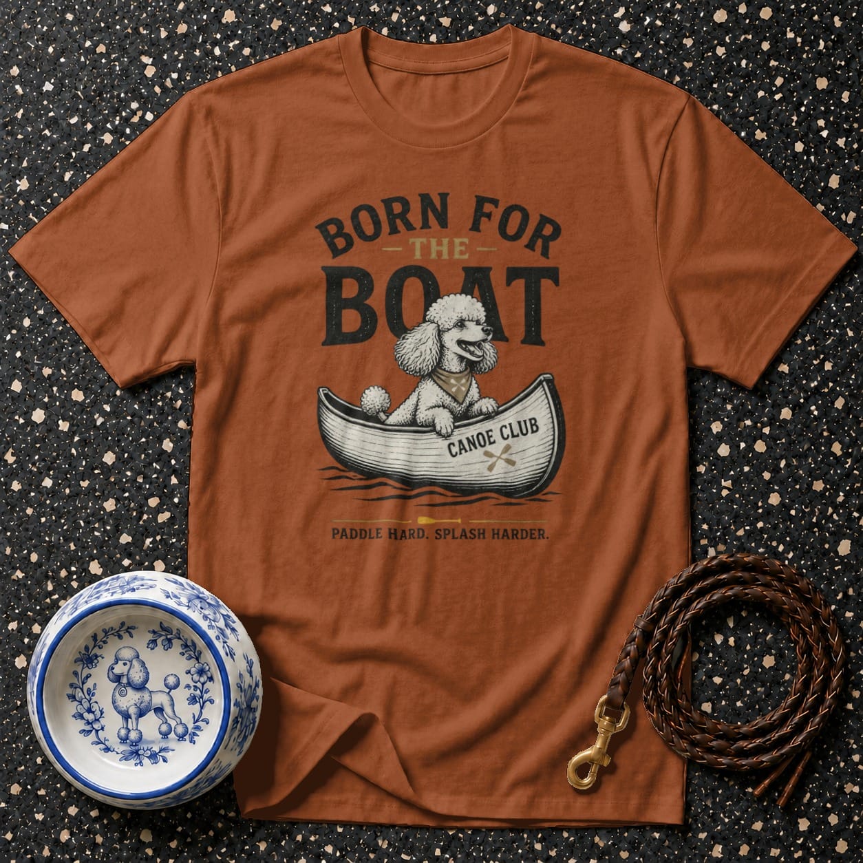 Brown t-shirt with a poodle in a canoe graphic and "Born for the Boat" text.