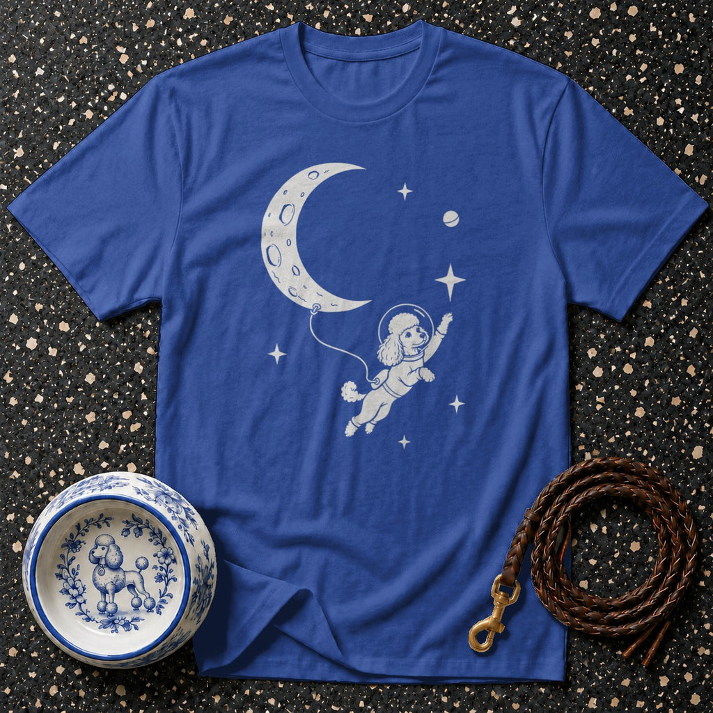 Blue t-shirt with a white graphic of a poodle in a spacesuit floating in space next to a crescent moon.