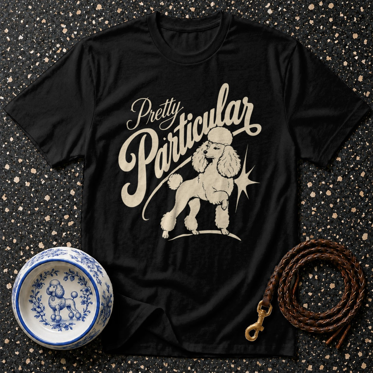 Black t-shirt with "Pretty Particular" text and a poodle illustration.