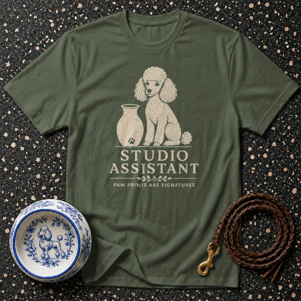 Olive green t-shirt with a poodle graphic and "STUDIO ASSISTANT" text.