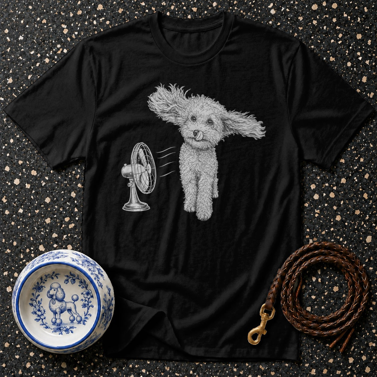 Black t-shirt with poodle in front of a fan and decorative dog bowl.