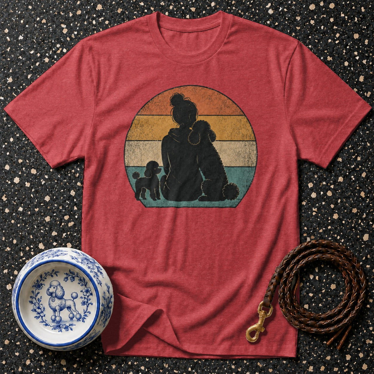 Red t-shirt with a retro sunset graphic of a woman and three poodles.