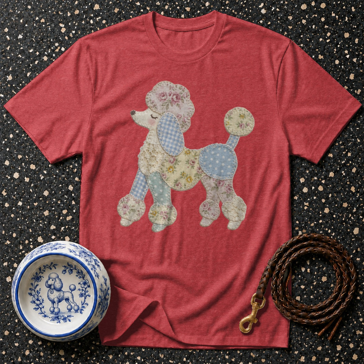 Red t-shirt with quilted poodle graphic, blue patterned dog bowl, and braided leash.