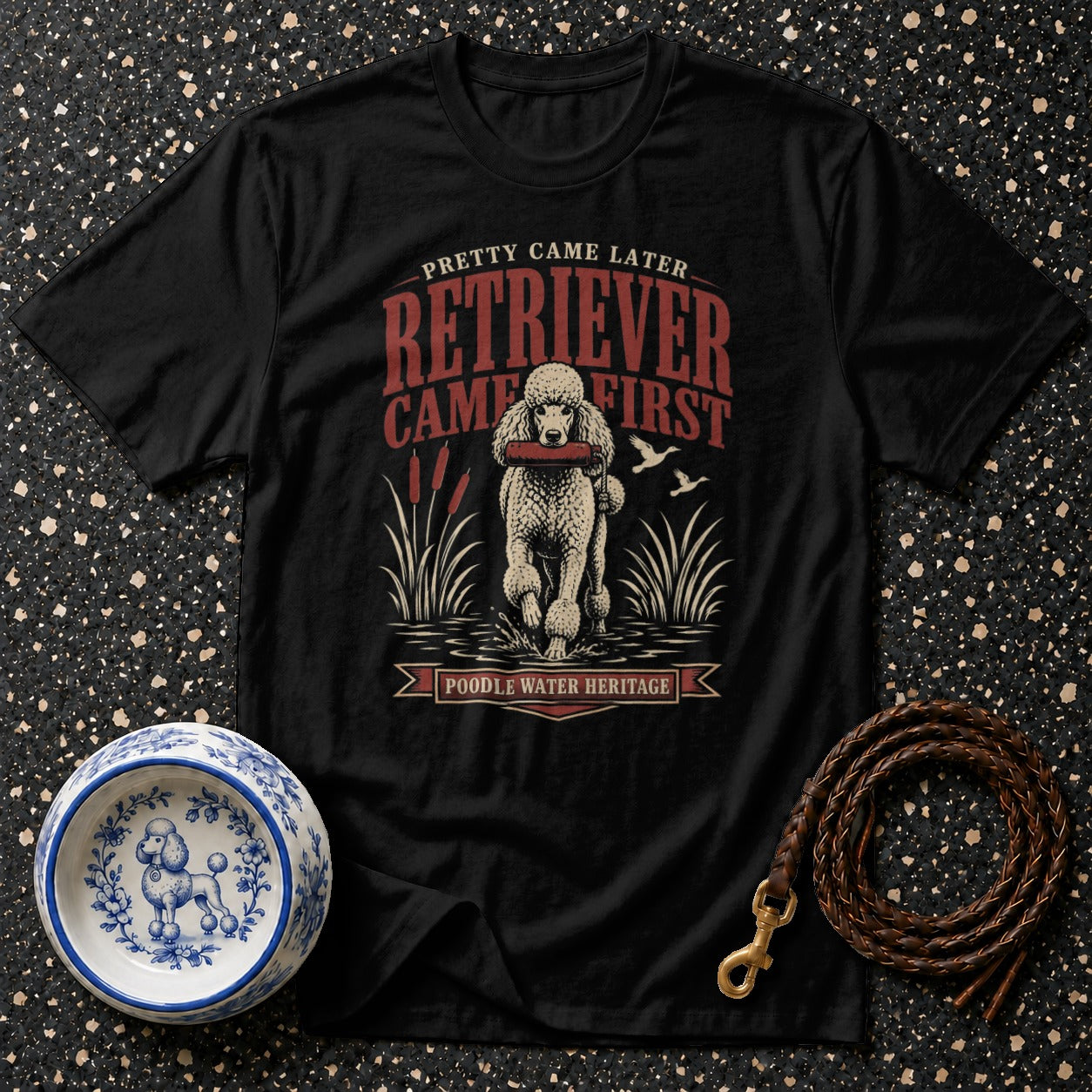 Black t-shirt with a poodle retrieving a stick, text "Pretty Came Later Retriever Came First".