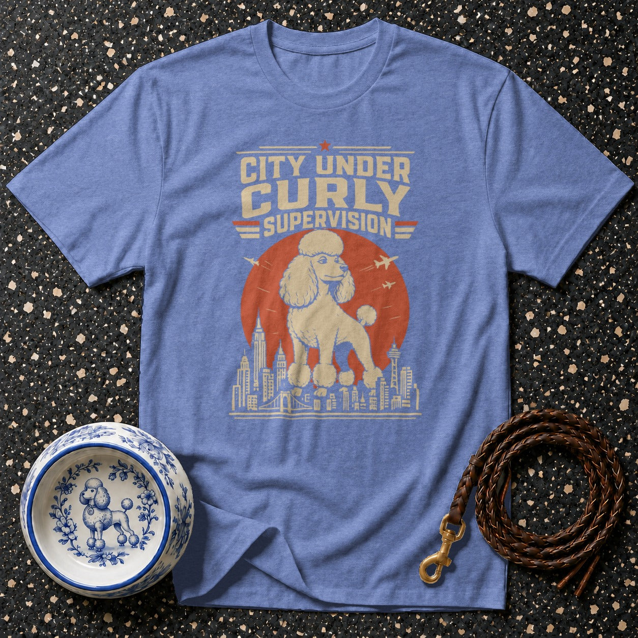 Blue t-shirt with "City Under Curly Supervision" and a poodle graphic.