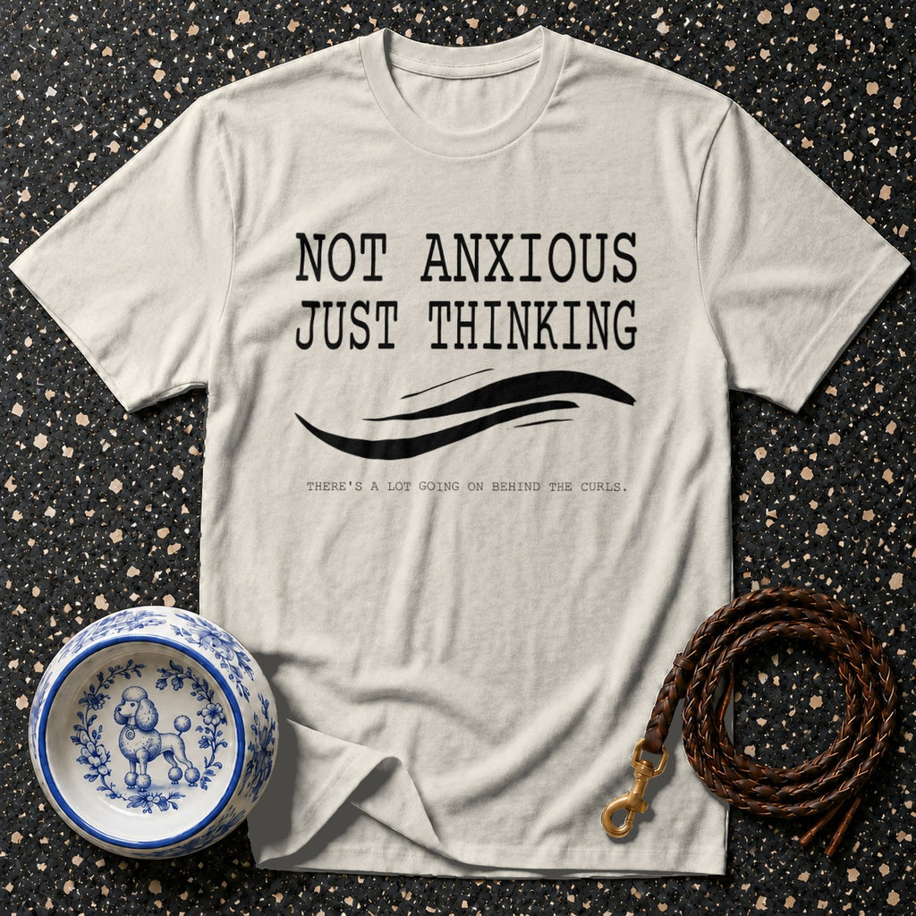 Cream t-shirt with black text: "NOT ANXIOUS JUST THINKING". Poodle bowl and leash nearby.