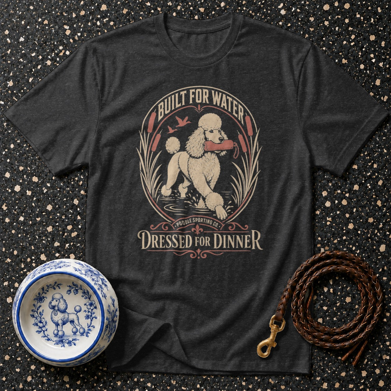 Dark gray t-shirt with a graphic of a poodle in water holding a stick.