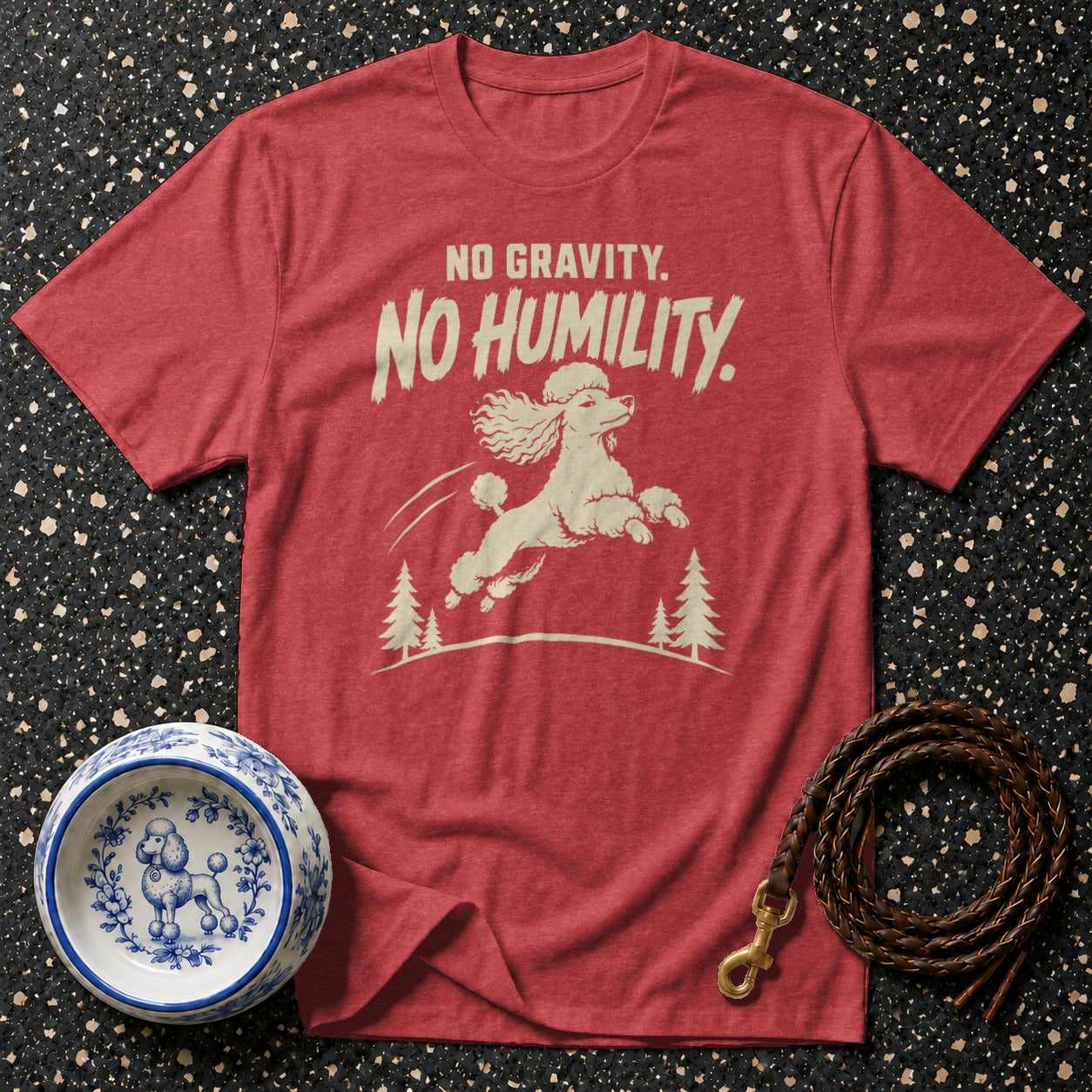 Red t-shirt with white poodle graphic, text "NO GRAVITY. NO HUMILITY."