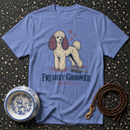Blue t-shirt with a cream poodle graphic and text "FRESHLY GROOMED. BRIEFLY."